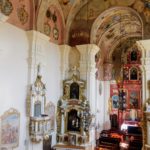 widok nawy z odrestaurowanymi freskami i stacjami drogi krzyżowej